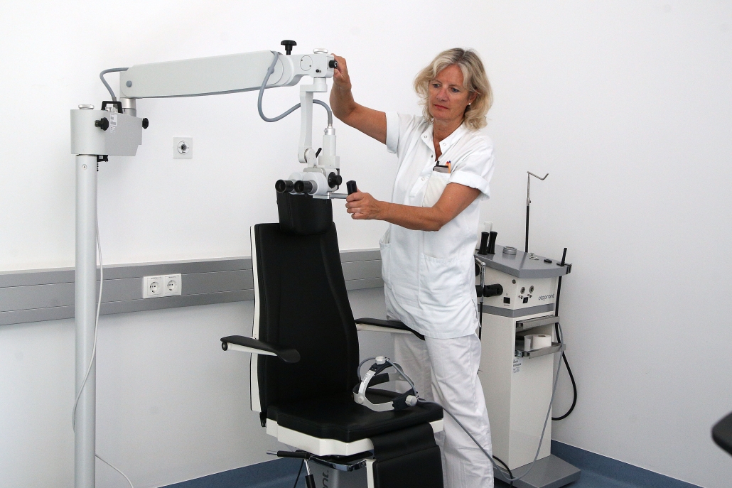 Ärztin stellt Gerät zur Augenuntersuchung ein