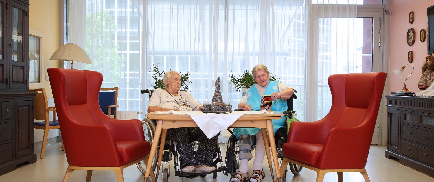 Zwei ältere Damen sitzen im Aufenthaltsraum der Pflege Leopoldstadt