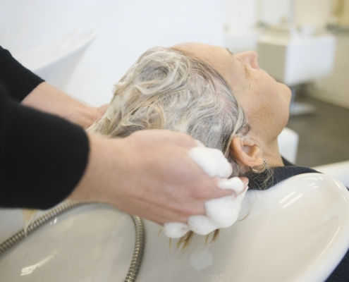 Ältere Dame bekommt ihre Haare beim Frisör gewaschen