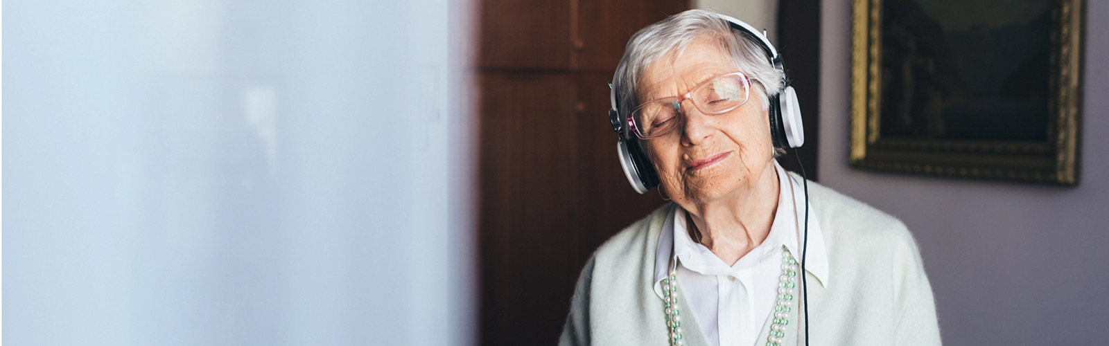 Alte Dame hört mit Kopfhörer Musik