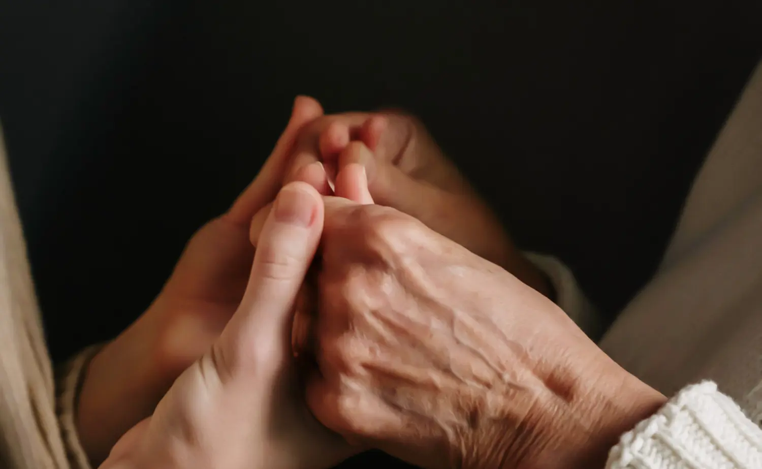 Person hält die Hand einer älteren Dame