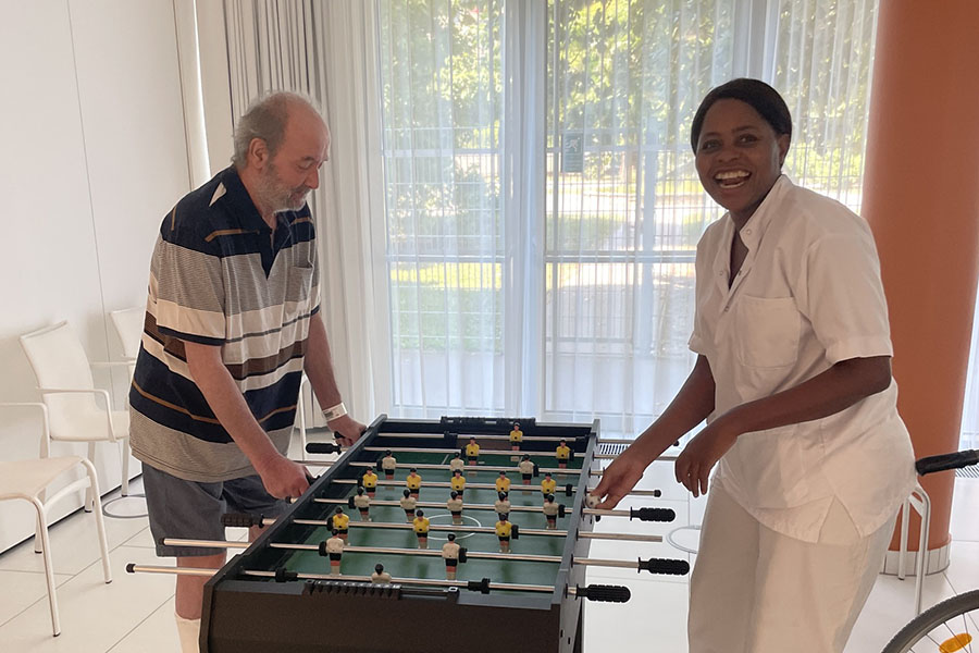 Bewohner spielt Tischfussball mit Pflegekraft in der Pflege Leopoldstadt