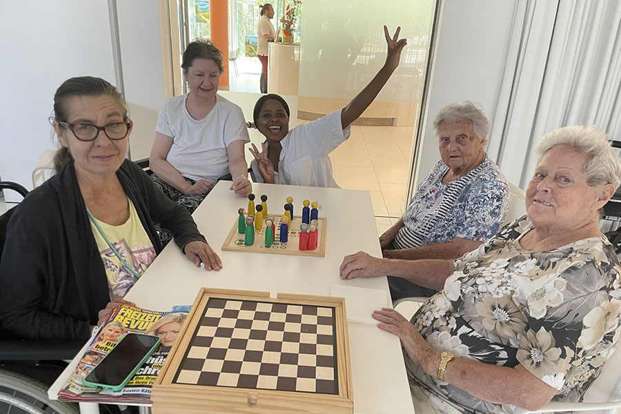 Bewohner*innen und Pflegekraft spielen Brettspiele in der Pflege Leopoldstadt