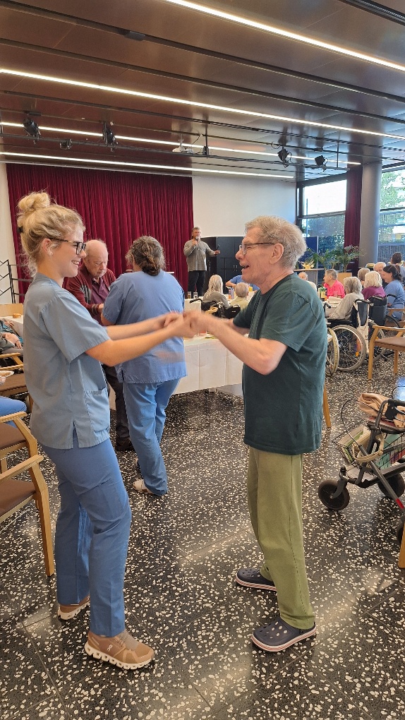 Pflege Liesing, Herbstfest, Bewohner tanzt mit Betreuerin