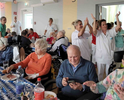 Betreuer*innen und Bewohner*innen beim Leberkäsfest in der Pflege Floridsdorf