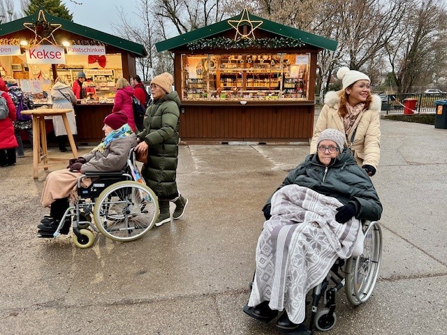 Bewohner*innen mit Begleitung am Adventmarkt in den Blumengärten Hirschstetten