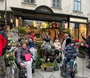 Pflege Rudolfsheim Fuenfhaus Adventmarkt Gruppe vor Blumenstand