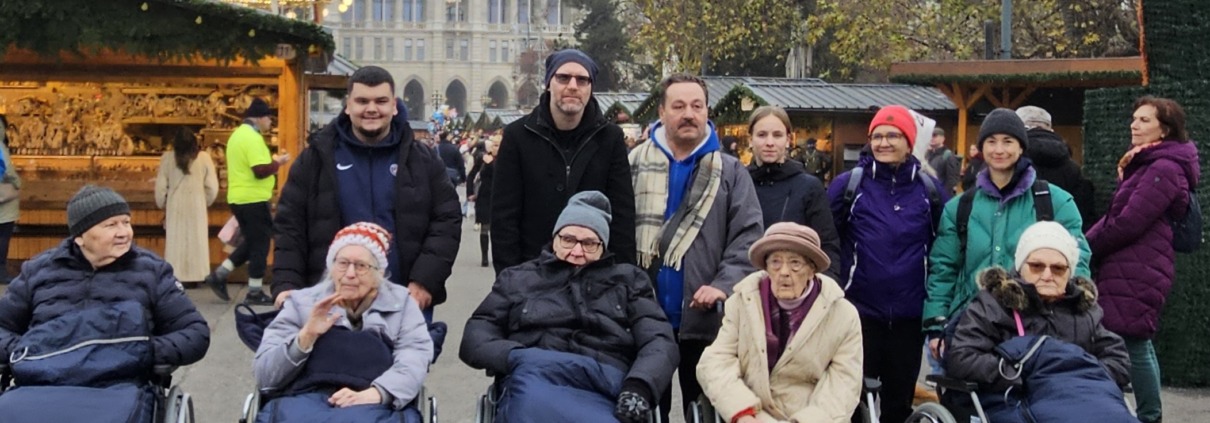 Pflege Rudolfsheim Fuenfhaus Adventmarkt Gruppe mit Betreuern