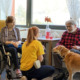Therapeutin mit Hund vor sitzenden Bewohner*innen in der Pflege Meidling